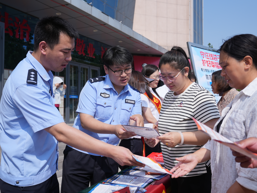 活动现场,民警为居民讲解常见的诱骗套路。刘友辉摄