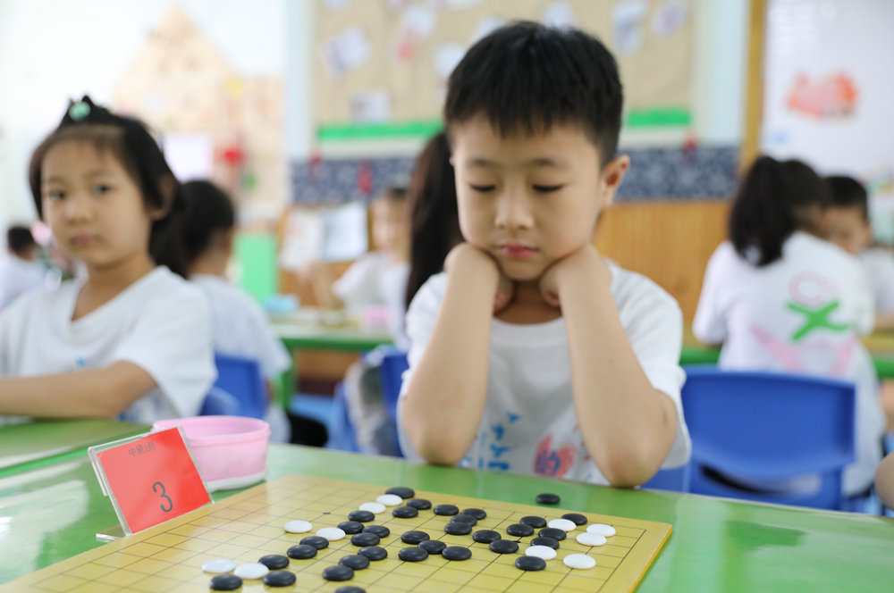 6月16日，小朋友在思考棋路。田博摄