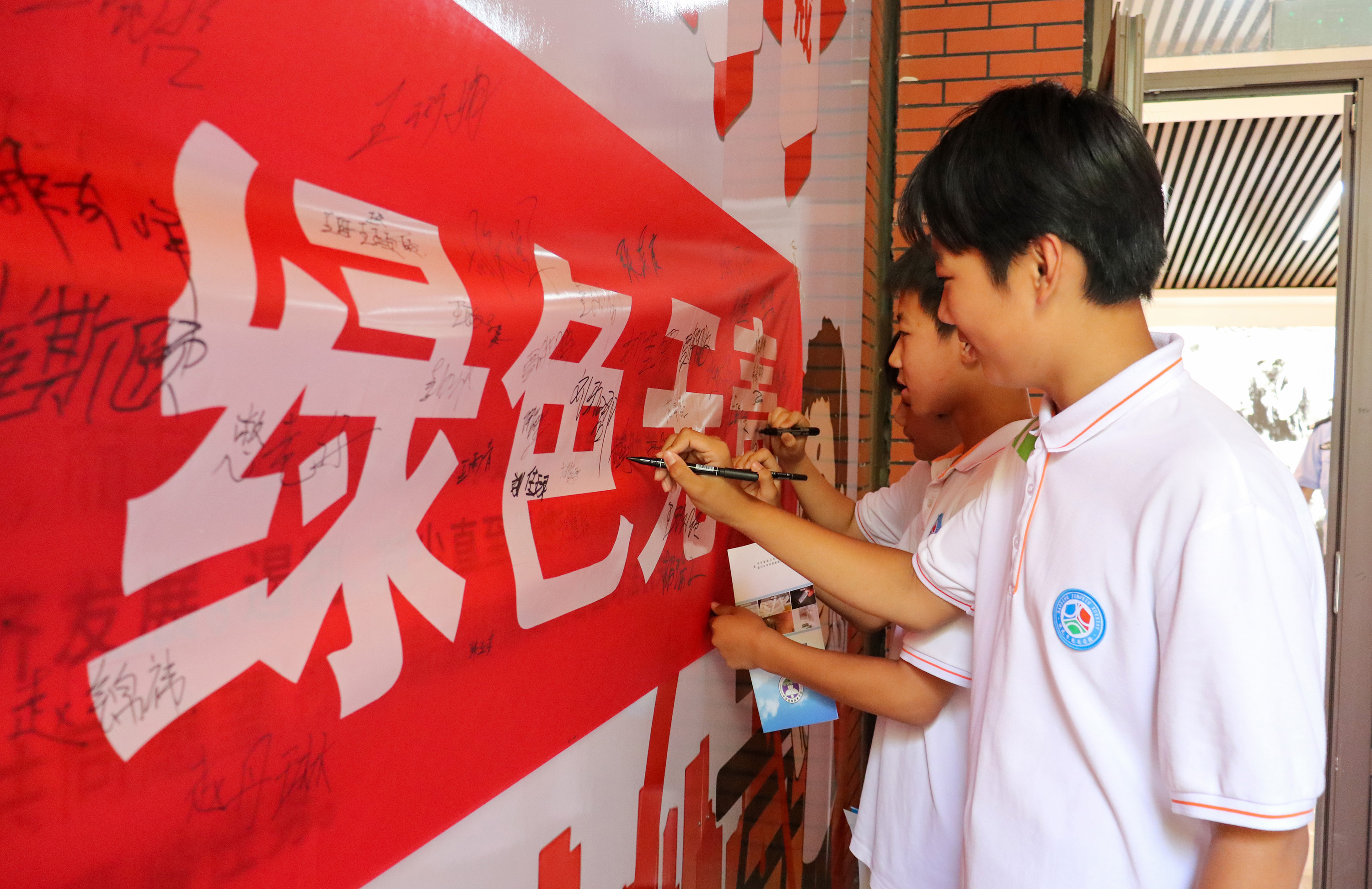6月24日，參與活動的青少年在禁毒宣傳橫幅簽名。耿培軒攝