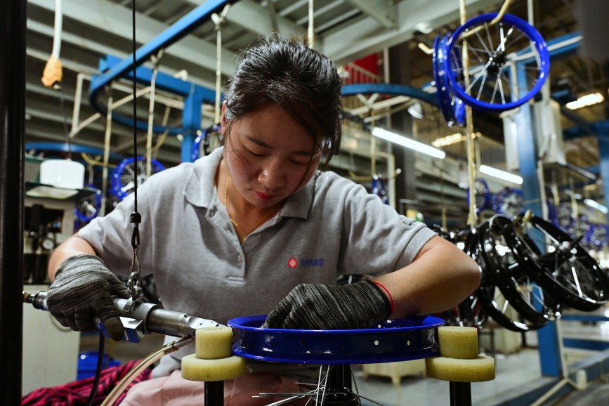 曲周县童车企业组装车间,工人在组装轮圈。王喜民摄