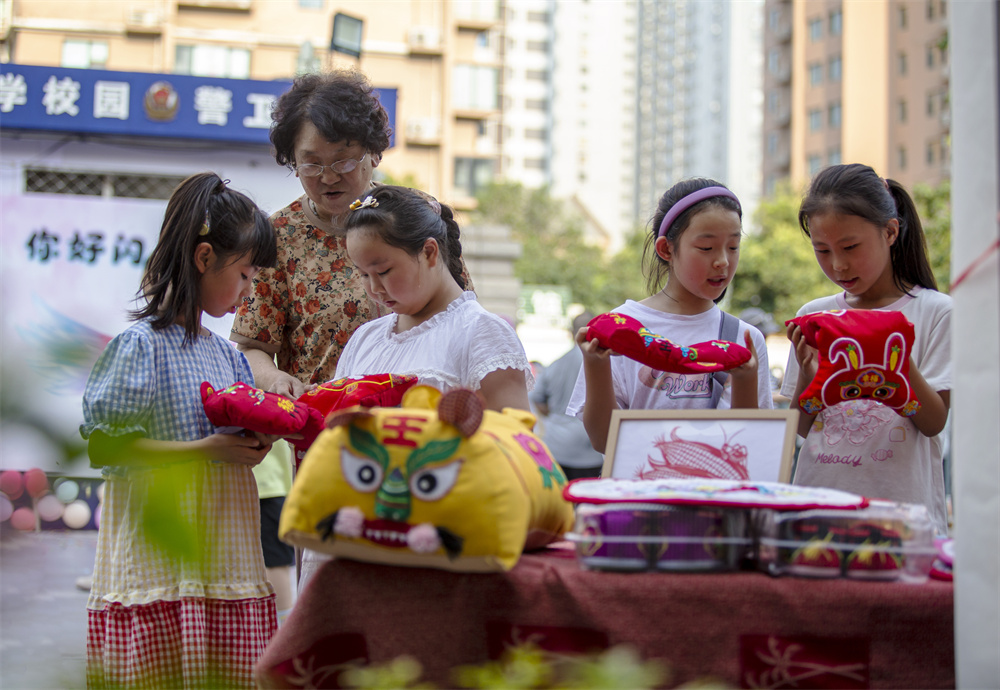 7月4日，河北省邯鄲市復興區百花小學，同學們在欣賞民間藝術虎頭枕。聶長青攝