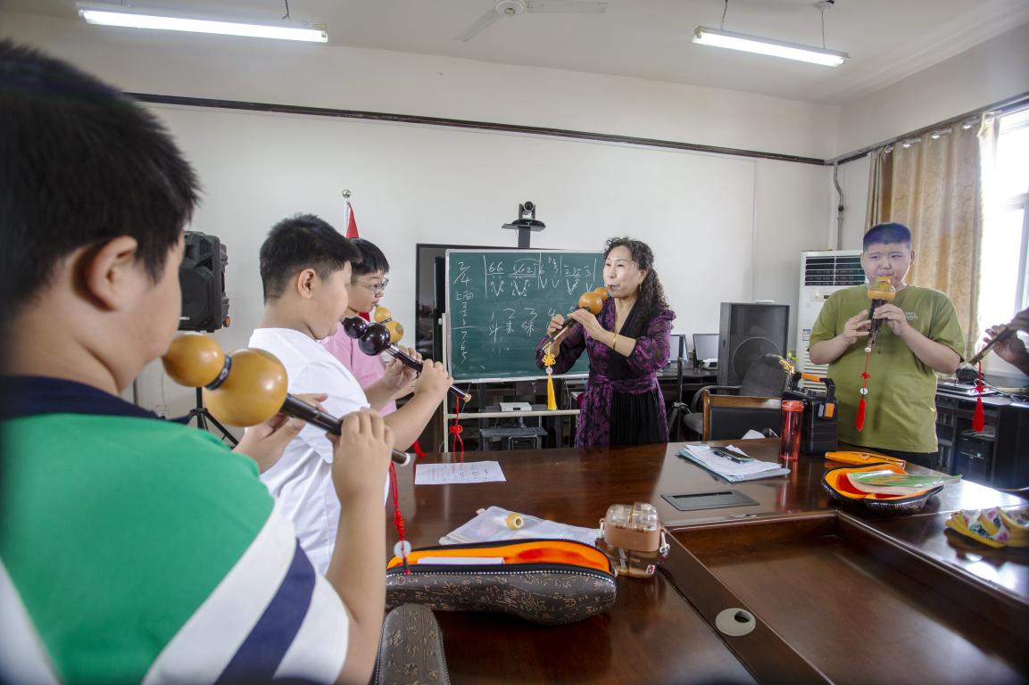 7月9日，河北省邯郸市复兴区文化馆，老师在辅导孩子们学习葫芦丝演奏。聂长青摄