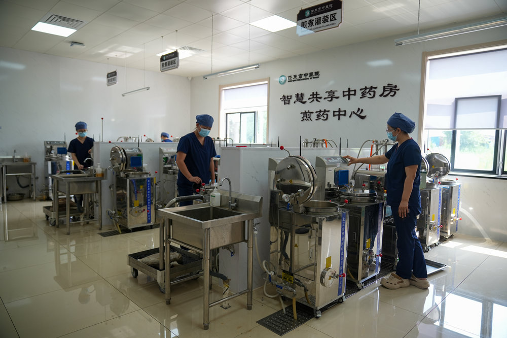 智慧共享药房工作人员在查看中药汤剂熬制情况。韩慧峰摄