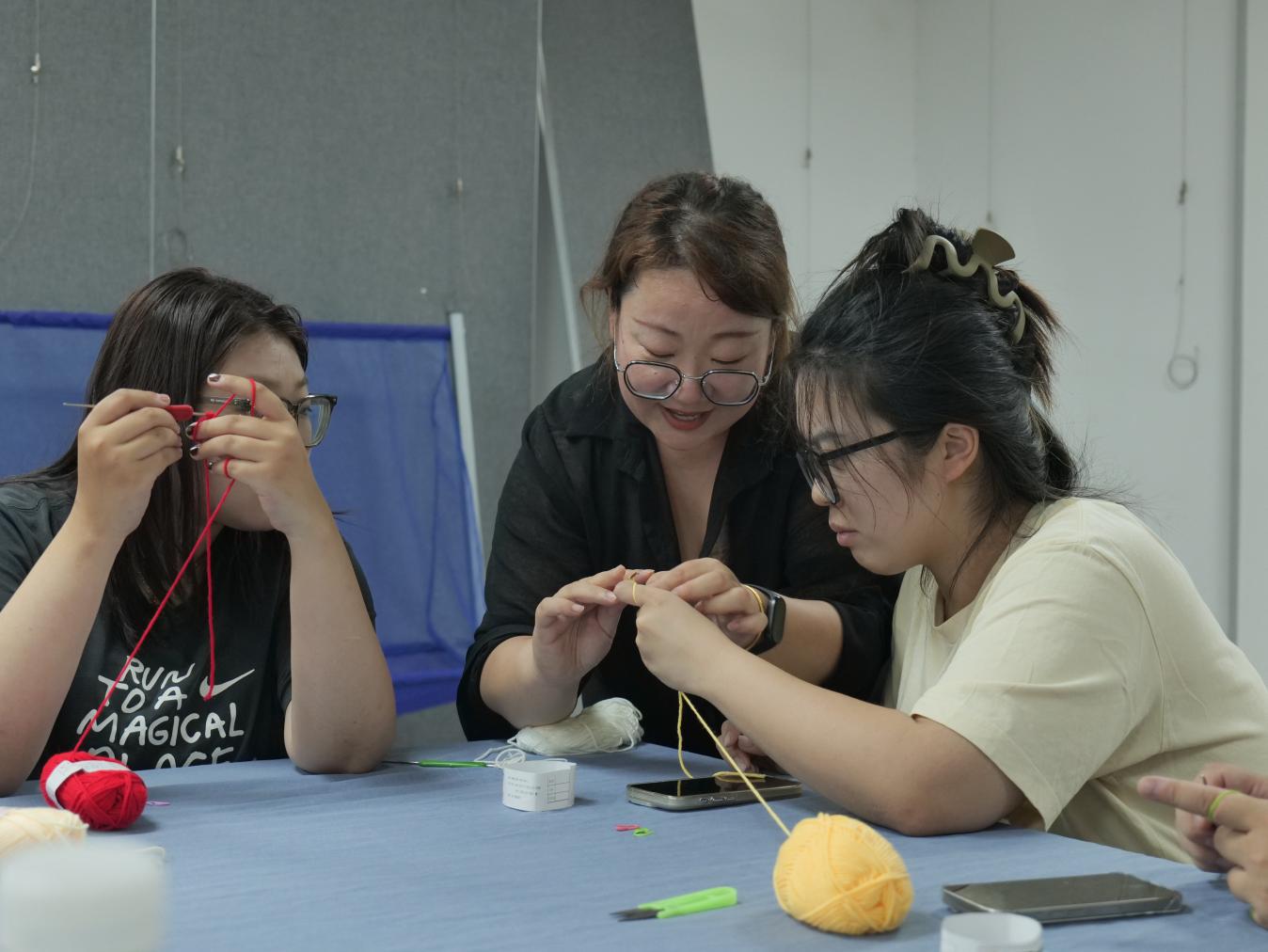 市民在老师的指导下学习手工编织。马鑫宇摄