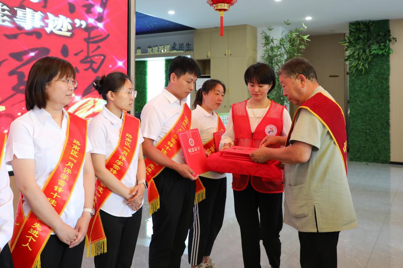 “中国好人”荣誉称号获得者唐建文为路南区“月评学雷锋十佳事迹”先进个人颁发荣誉证书（资料图）。张宇茜摄