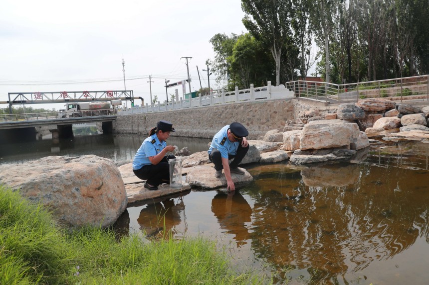 工作人員對七節河南段水體進行取樣。趙端攝