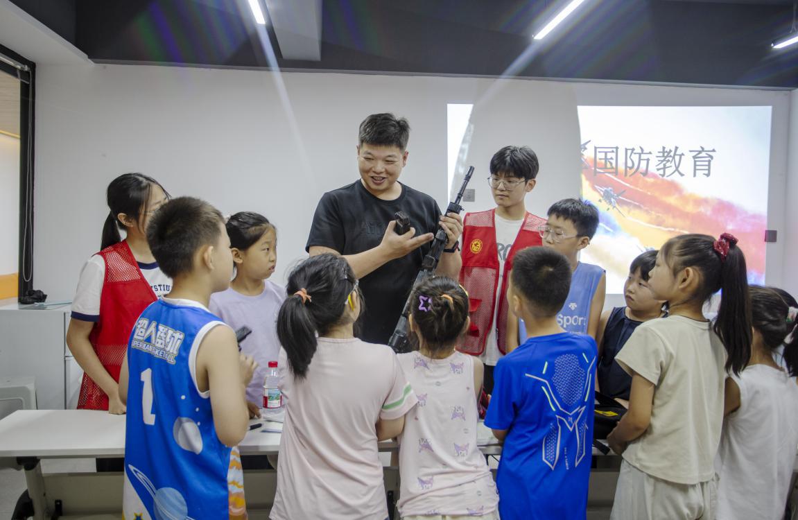 2025年7月14日，河北省邯郸市复兴区化林路街道将相苑社区，退伍军人教官为孩子们讲解枪械构造，培养孩子们的国防观念。聂长青摄