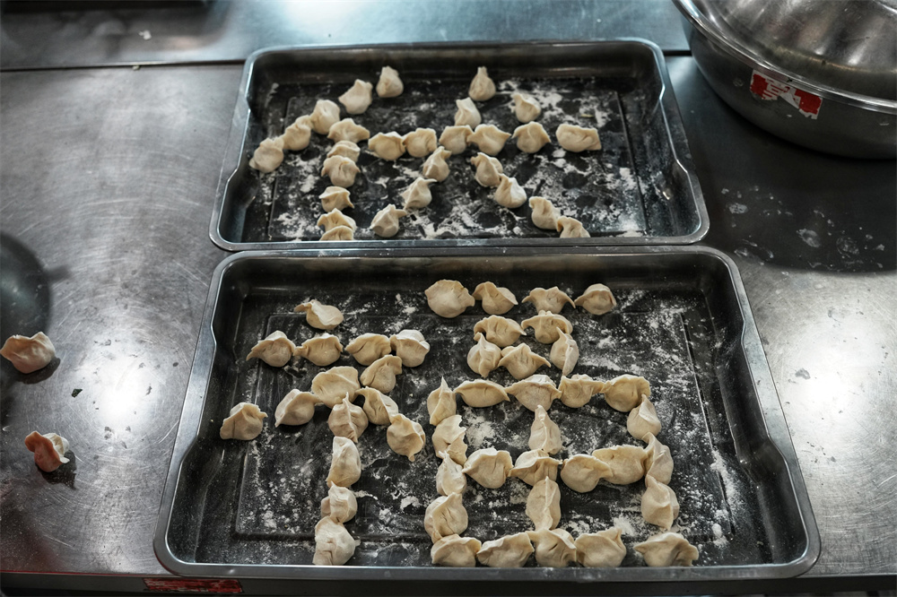 遷安市沙河驛鎮志願者用餃子擺出的“伏”字和“福”字。張澤慧攝