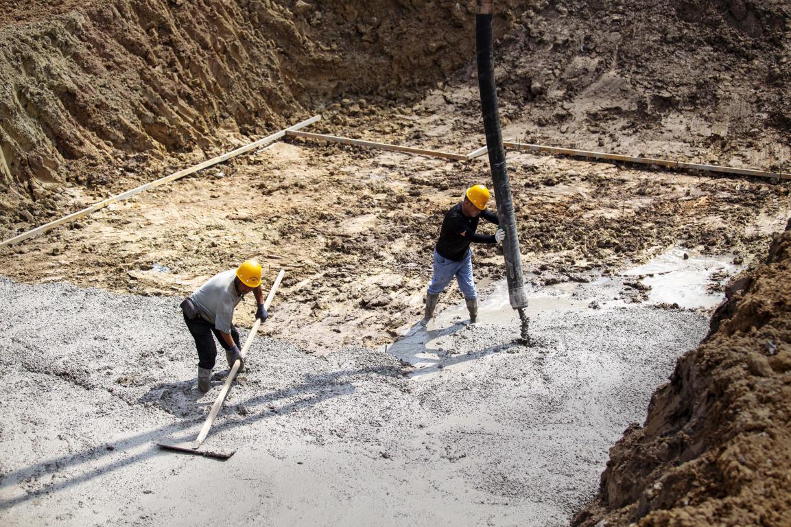 7月21日，河北省邯郸市复兴经济开发区产业园，河北冶建新力科技世仓项目建设现场，工人正在浇筑地基。聂长青摄