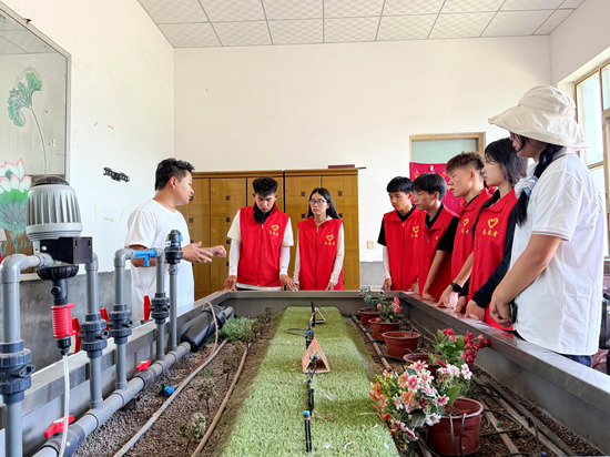 志愿者们观摩学习水肥一体化系统模型。李子晨摄
