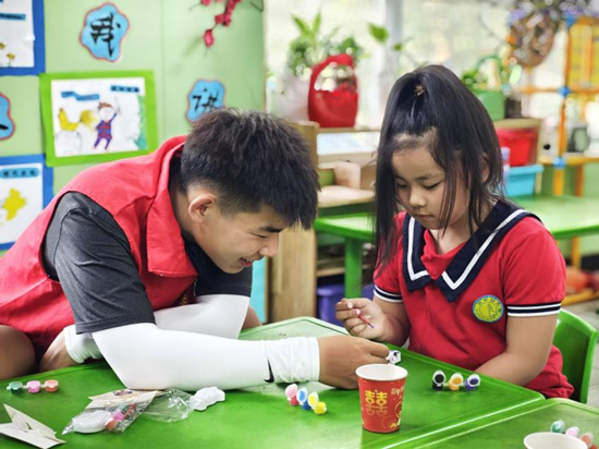 志愿者与幼儿园小朋友做创意手工。李子晨摄