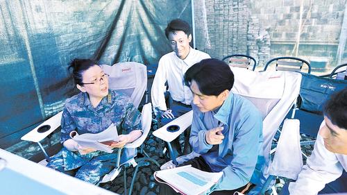 导演陈力（左一）在《浴血荣光》拍摄现场。 张傅茵供图