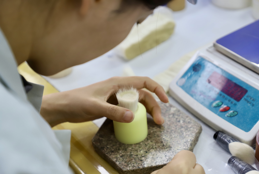 7月22日，在河北省青县某化妆刷生产企业，工人正在对毛刷进行称重。陈雷摄