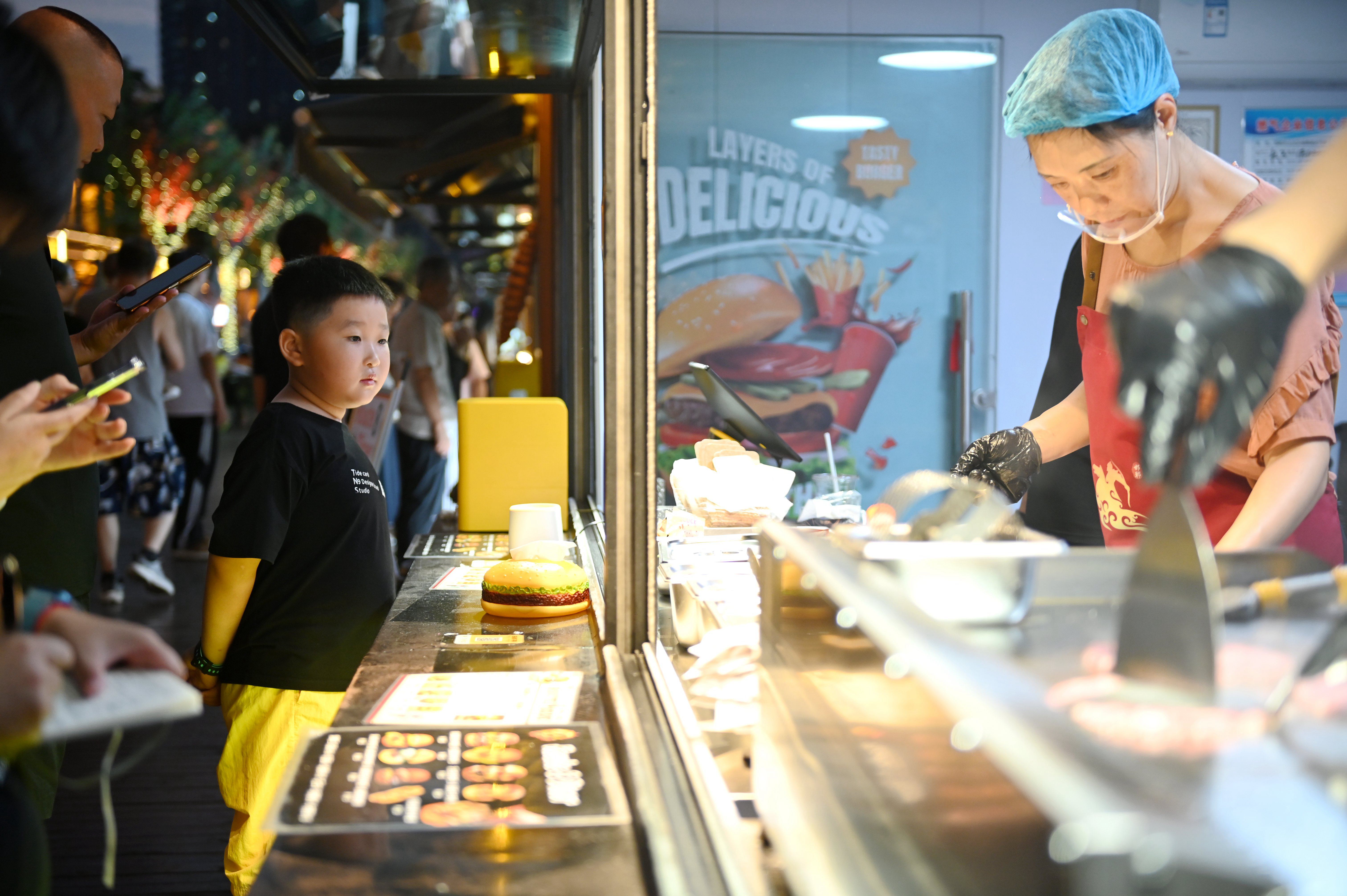 市民正在在摊位选购美食。段晨曦摄