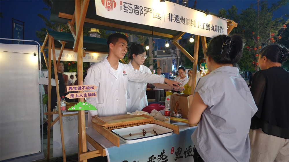 药膳市集区市民品尝蜜丸。李青默摄