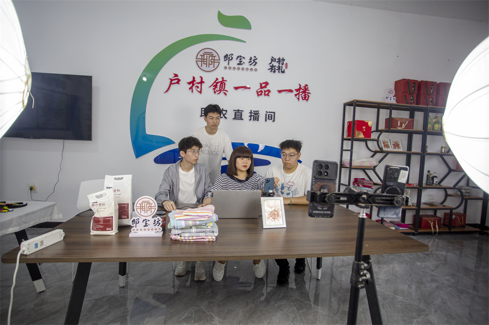 7月25日，河北省邯郸市复兴区户村镇齐村，返乡大学生在参观直播基地，听取工作人员介绍直播经验。聂长青摄
