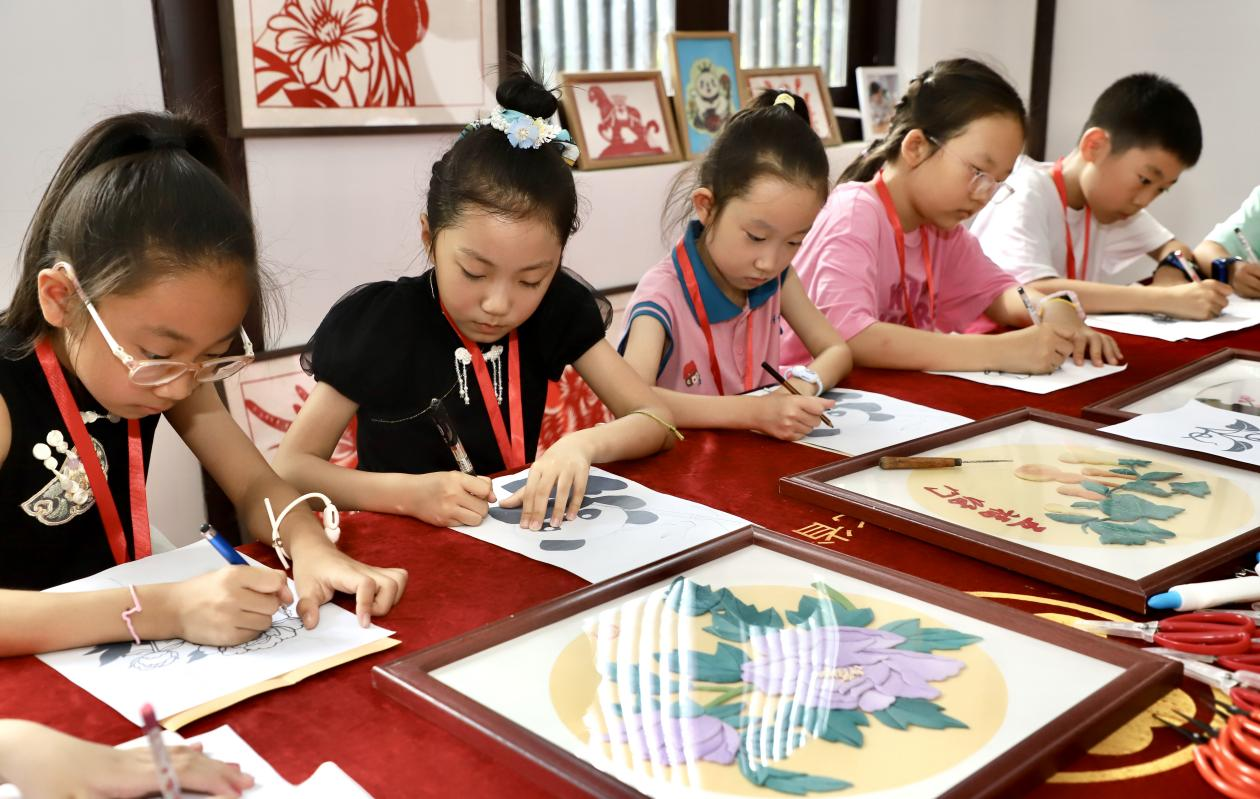 孩子们认真制作非遗布贴画。陈雷摄