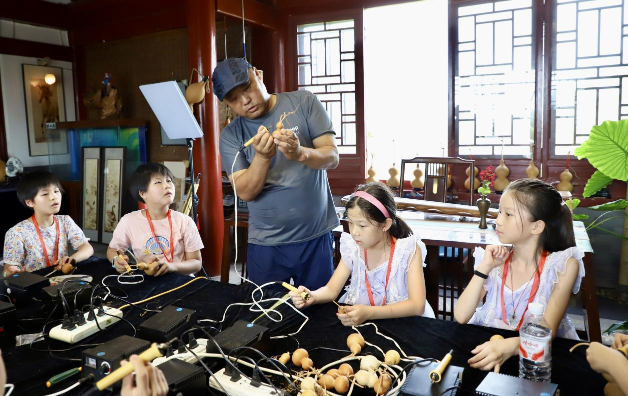 非遗葫芦烙画传承人为孩子们示范非遗葫芦烙画技巧。陈雷摄