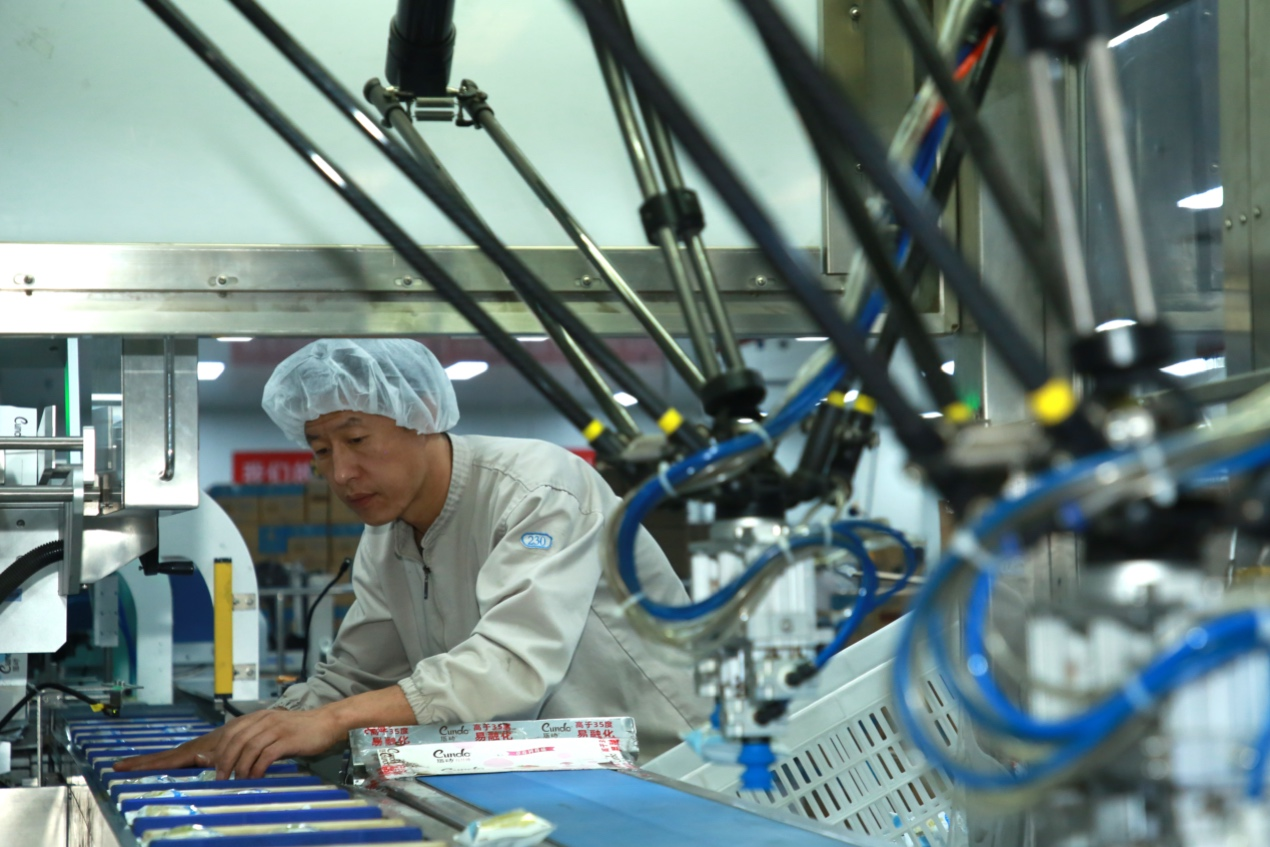 7月22日，在河北省青县某食品厂的车间内，工人正在忙碌工作。殷实摄