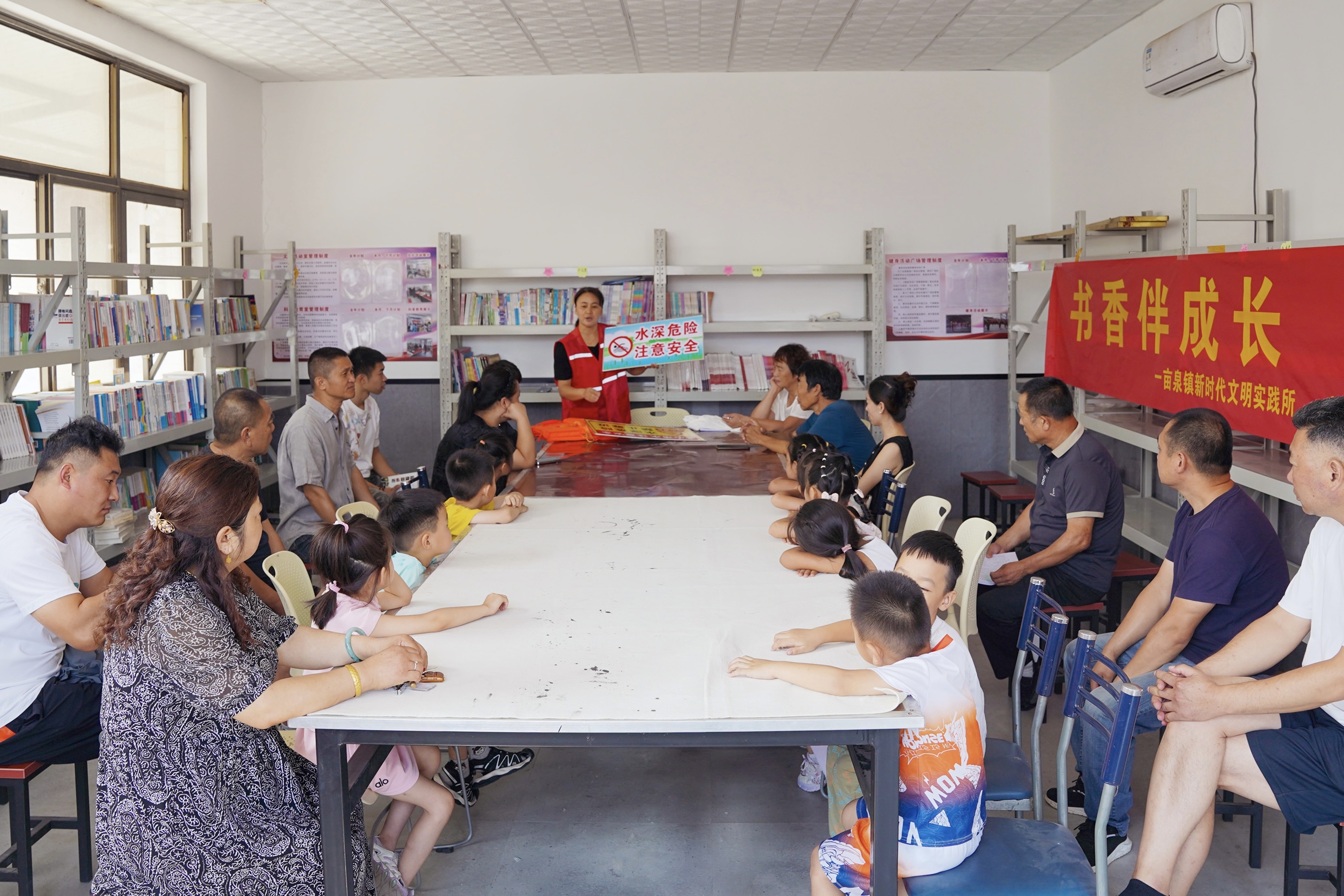 在一亩泉镇南奇村农家书屋,志愿者给孩子们讲防溺水知识。王晨宇摄