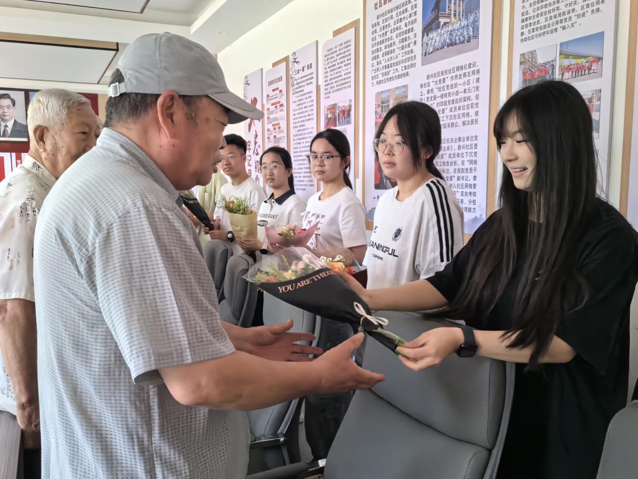 新兴社区青年学生为退伍老兵献花。刘聪摄