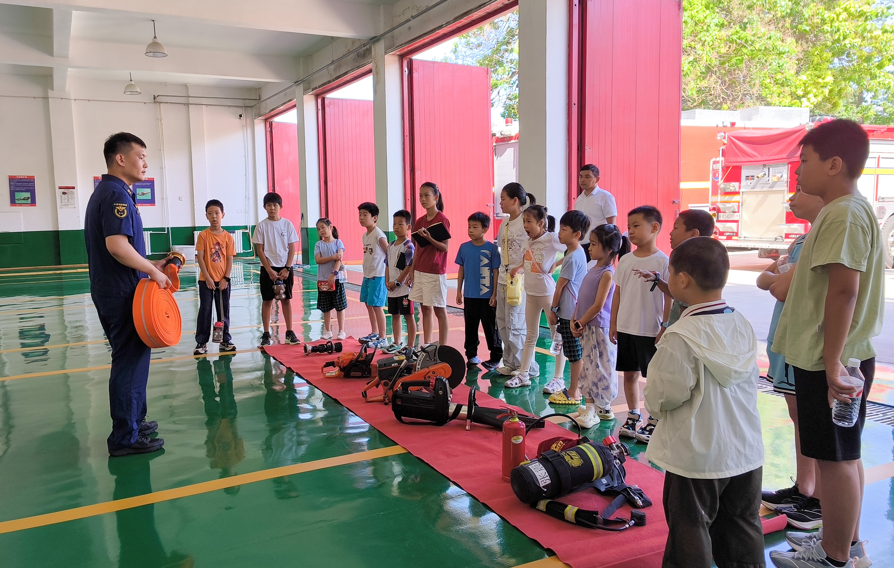 7月30日,消防员向社区儿童展示消防救援器材。耿培轩摄