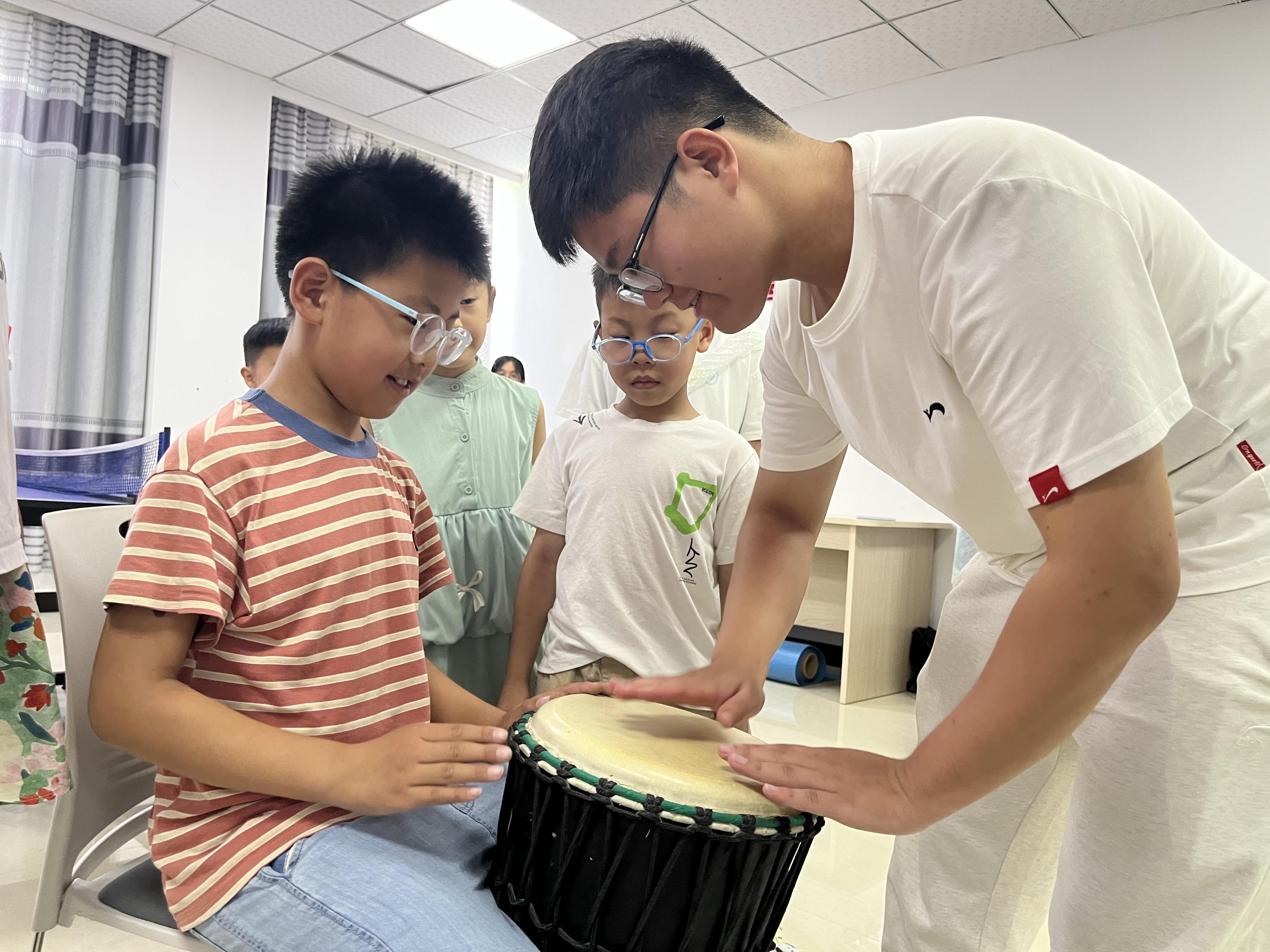 音乐课上,吸引了众多孩子与老师互动体验。孙雨晴摄