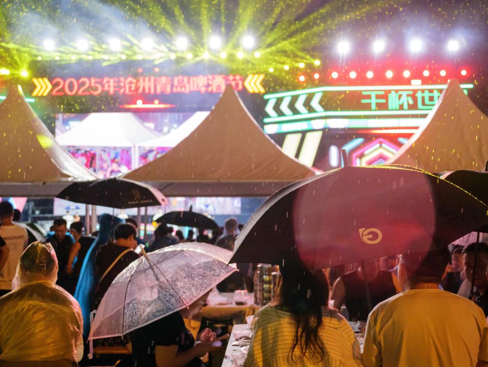 小雨也阻挡不住人们到啤酒节休闲度夏的热情。孔超摄
