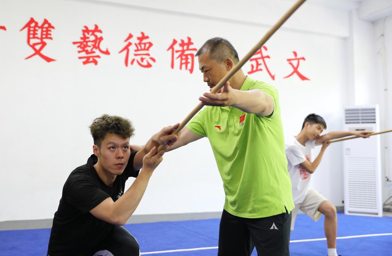 8月10日,在沧州志海武术馆,敬学才纠正澳门学员武术动作。田博摄