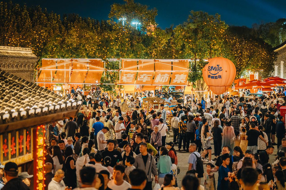 在河头老街，游客们正在观赏摆放在景区的各种老式汽车。魏永摄