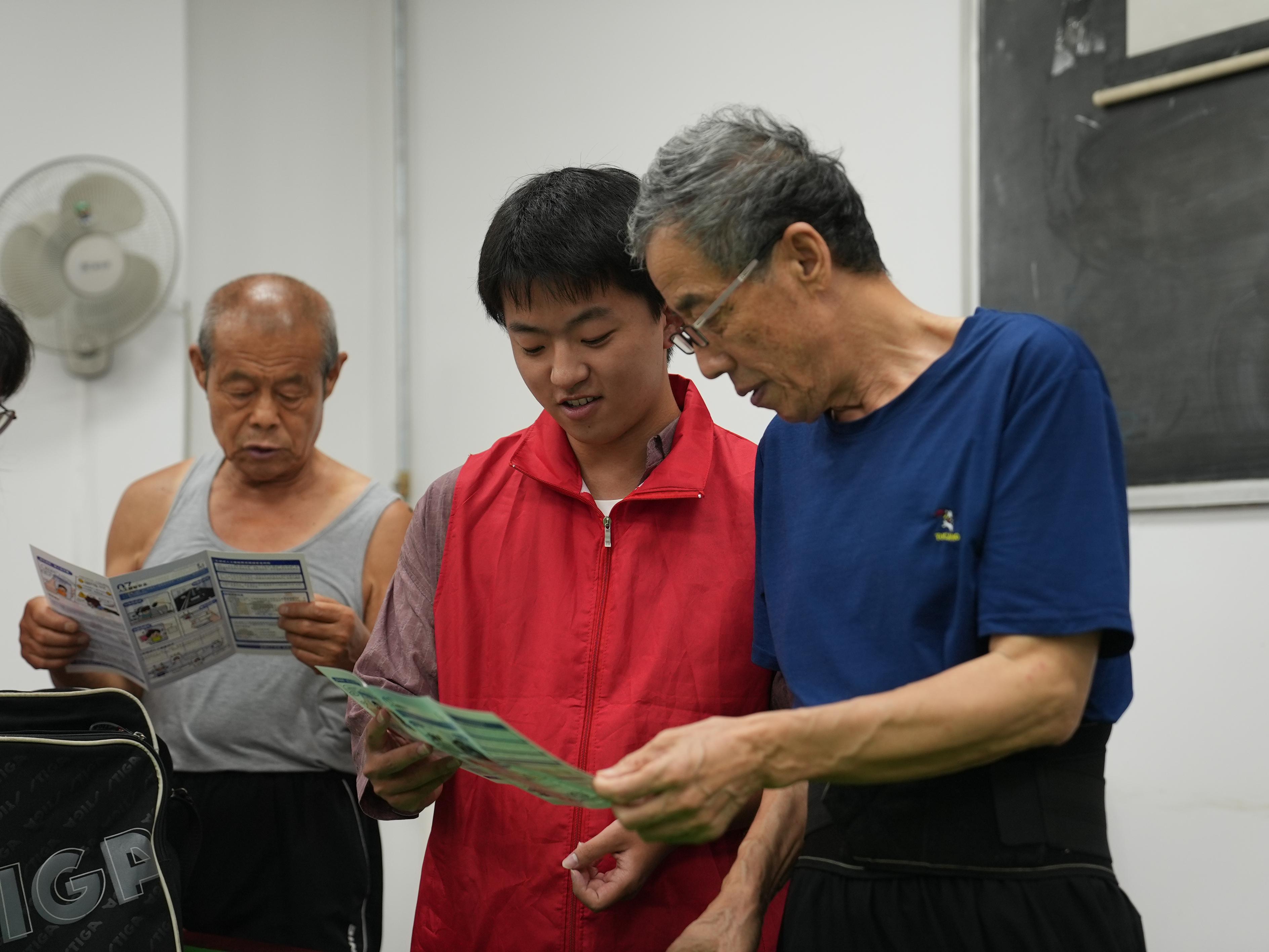大学生志愿者为居民讲解电信诈骗常见套路。刘一明摄