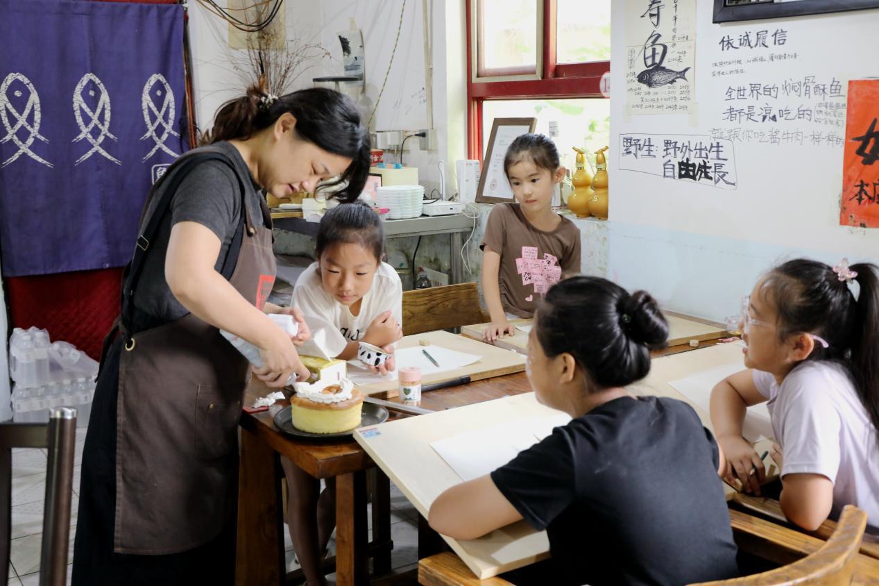 8月12日，在易县安格庄村公益美育课堂上，史丽杰正在现场制作小蛋糕供孩子们绘画参考。付鑫源摄