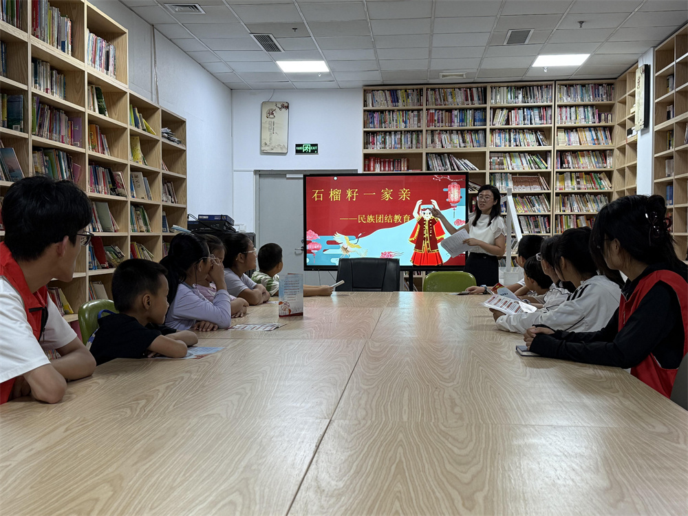 “红石榴”志愿者为青少年讲解民族团结进步知识。刘楠摄