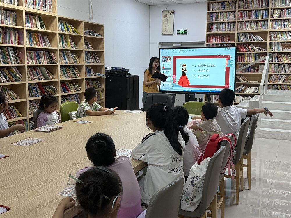 “红石榴”志愿者为青少年讲述民族团结故事。刘楠摄