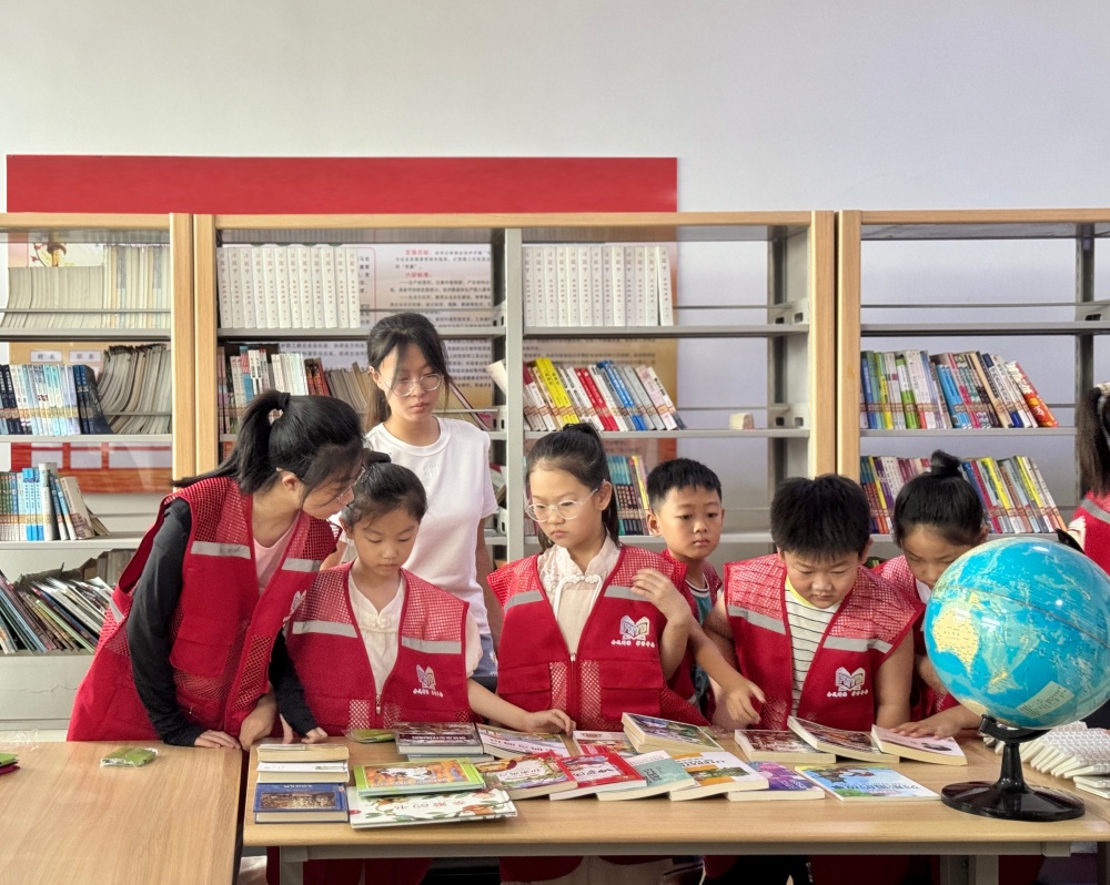 在图书馆内，返乡大学生与孩子们一起开展活动。杨雨馨摄