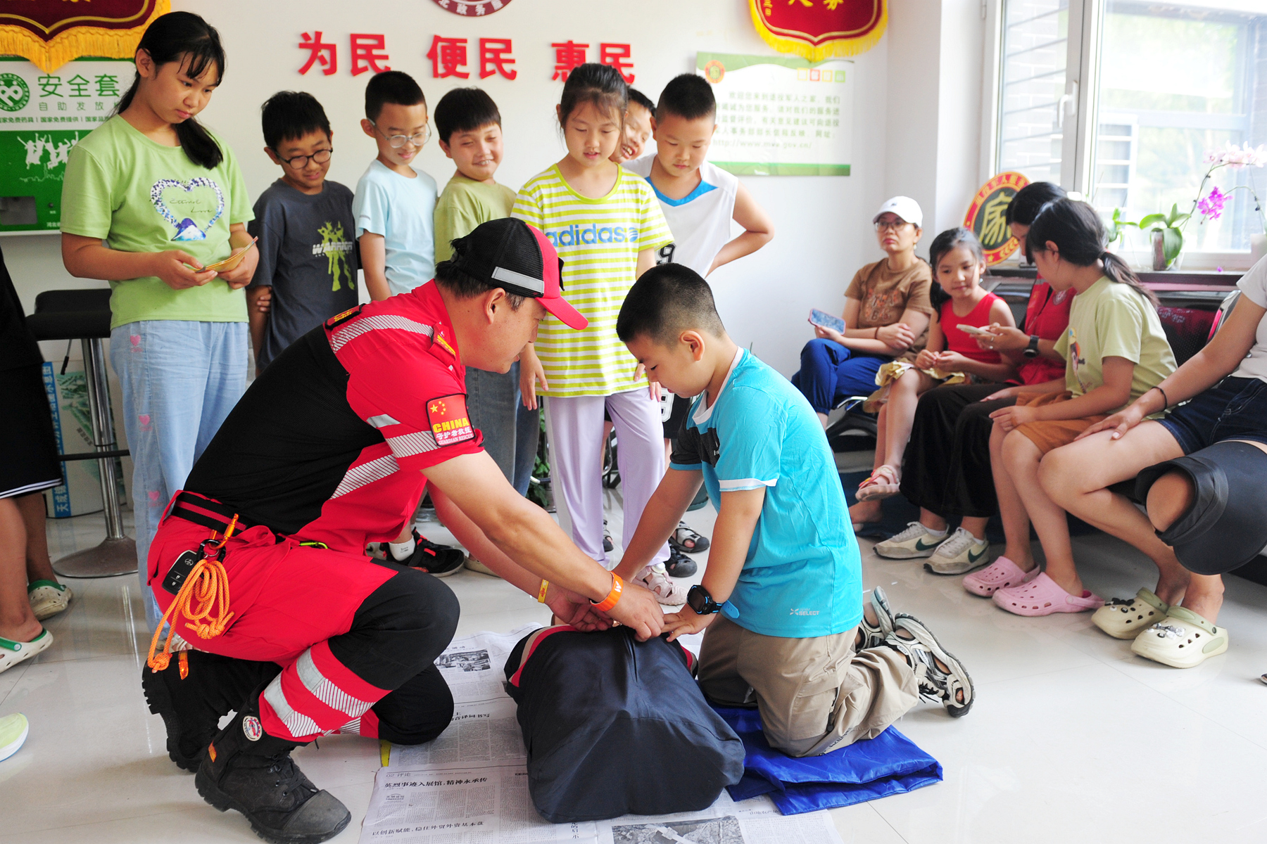 在老师带领下,孩子们学习体验心肺复苏实施方法。王勤诣摄