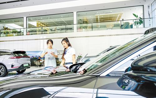 近日，石家庄市民賈梅（左）在裕華汽車園一家4S店選購新能源汽車。 本報記者 李東宇攝