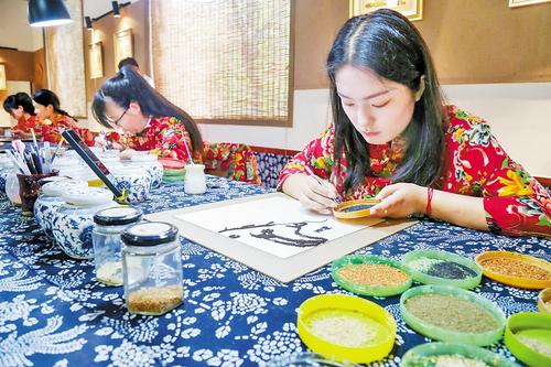 8月16日，寿东村粮画工坊员工在进行粮画创作。 本报记者 田明摄