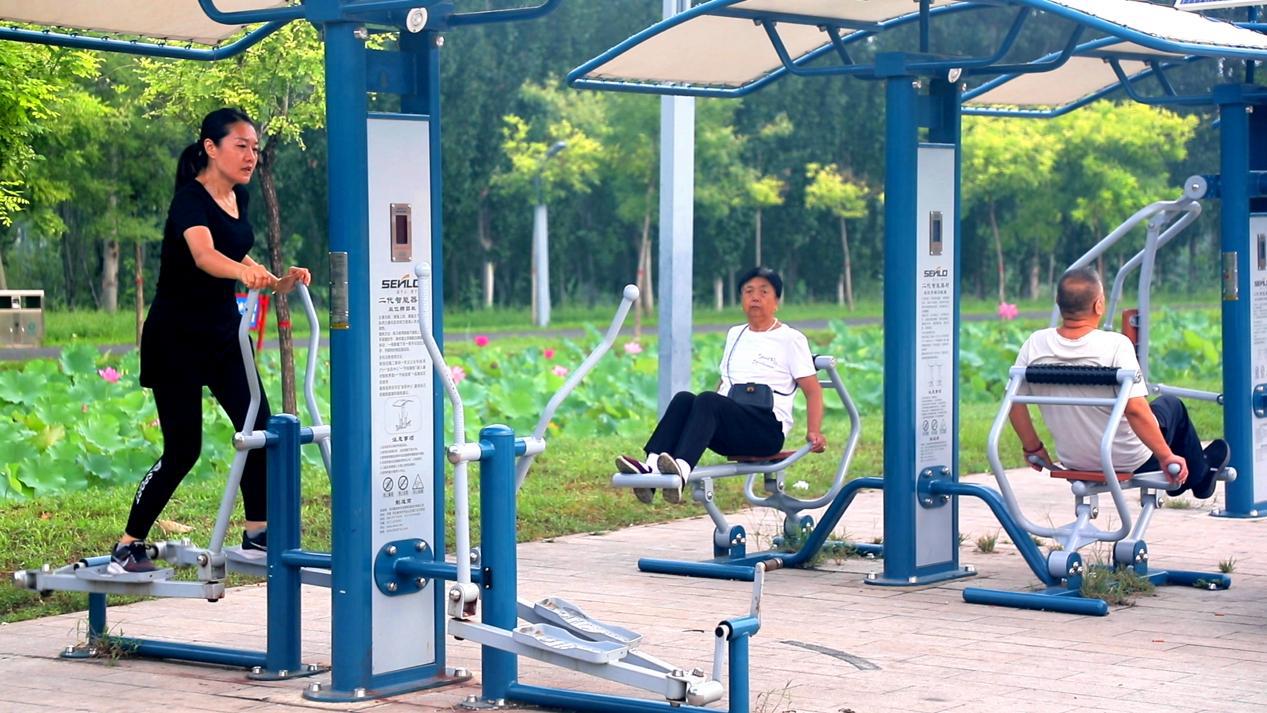 市民们利用运河周边健身器材进行晨练。张志宇摄