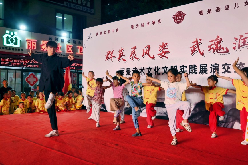 武术爱好者与现场的孩子们互动，演练简单招式。杨洋摄