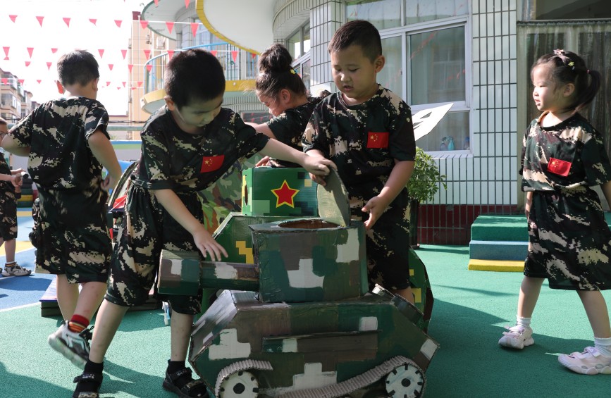 9月1日，小军迷在体验家长制作的武器模型。田博摄