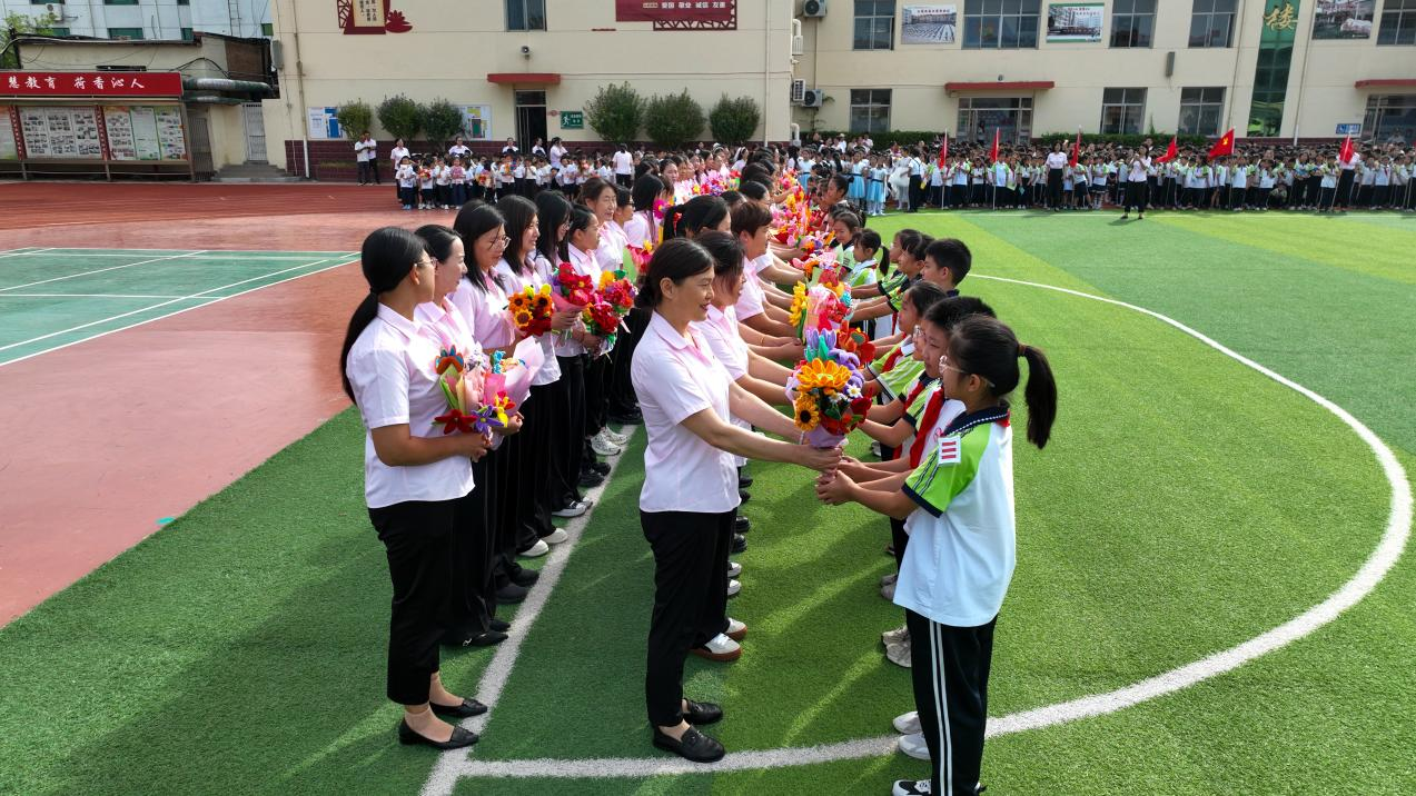 任丘市实验小学学生向老师献花。韩慧峰摄