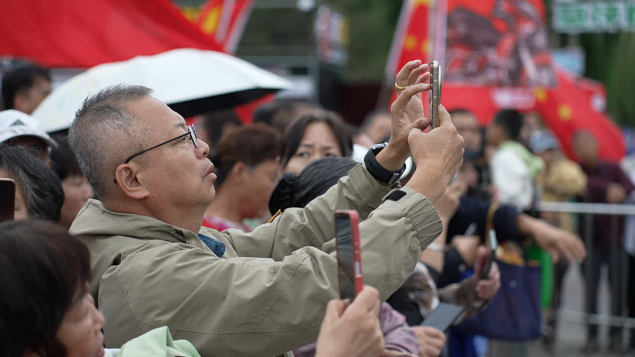 在百狮园南川古渡水路巡游表演区,游客们纷纷举起手机,记录这场融合古今的文旅盛宴。贾玉龙摄