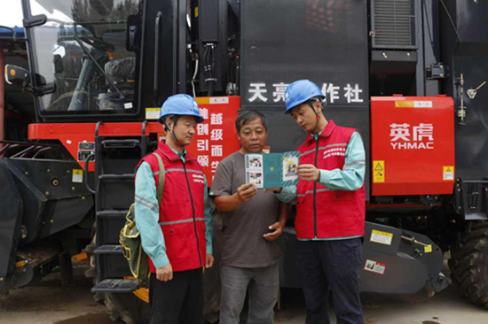 网石家庄市栾城区供电公司工作人员向收割机手讲解安全注意事项。卞策摄