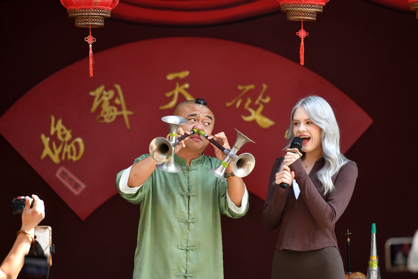 9月25日，在吴桥杂技大世界，杂技艺人用鼻子吹唢呐与游客比赛拉长音。苑立伟摄