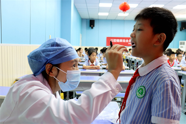 白明月醫生在為學生檢查口腔。李謙攝
