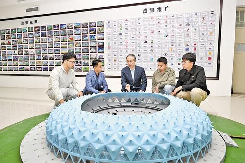 10月17日,刘庆宽(左三)和学生对体育场大跨度结构风荷载和风环境进行研究。 本报记者 史晟全摄