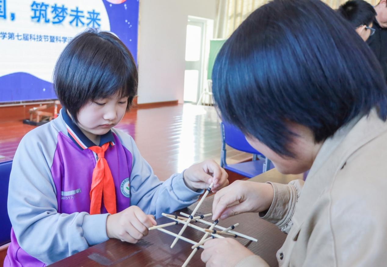 学生们在用筷子搭建木拱桥。郭春朝摄