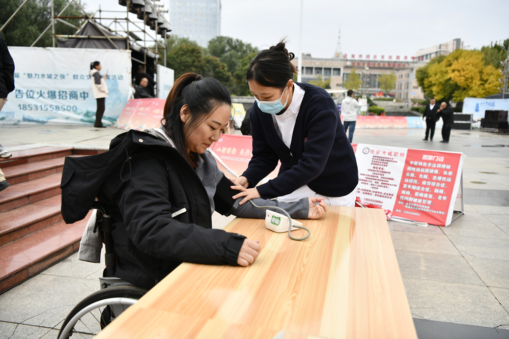 医务志愿者为市民测量血压。梁玉水摄