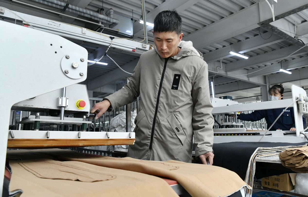 10月22日，工人在肃宁县一家针纺服装企业生产车间裁剪工位工作。苑立伟摄